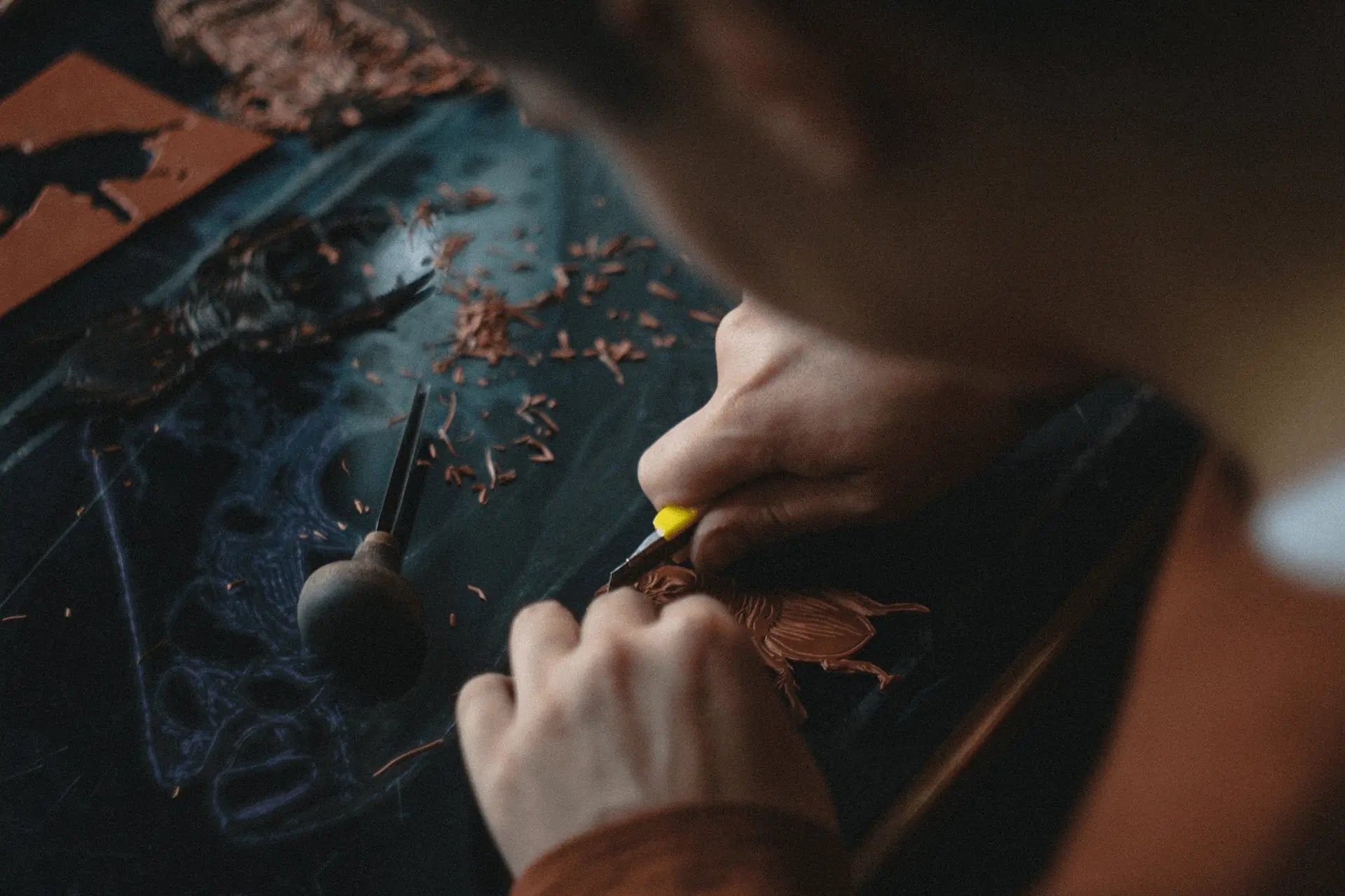 A person is making handmade leather goods, with a calm and focused vibe.